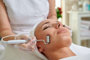 Female receiving microcurrent therapy in spa cosmetologist professional services.