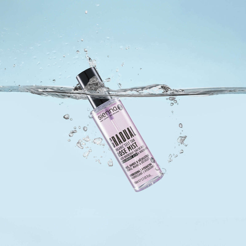 Bottle of cosmetic product in water with splashes on color backg