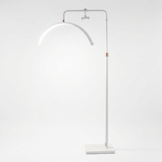 White floor lamp with curved arm on a white background