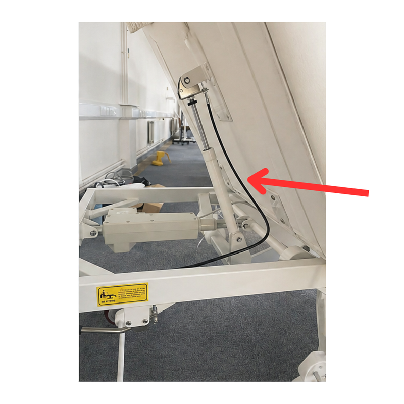 Replacement wire for beauty bed - mechanical component with a red arrow pointing to it in an indoor setting