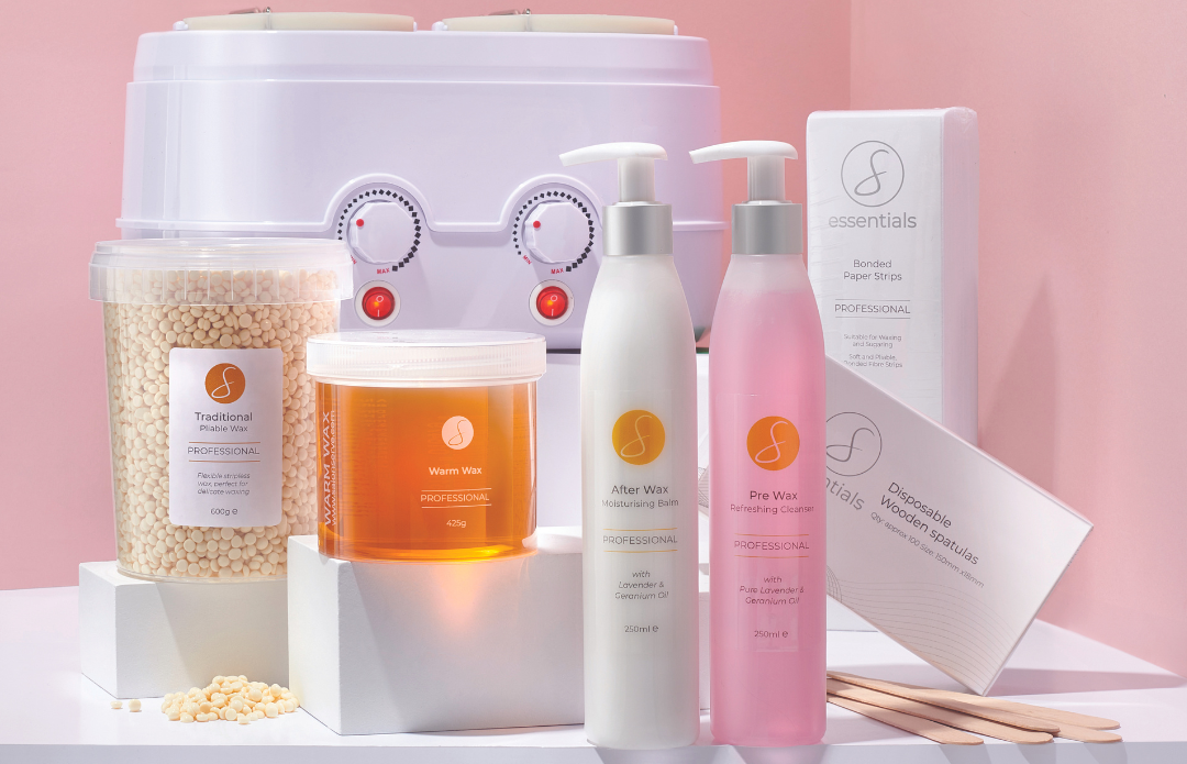 Assorted skincare products on a white surface with a pink background